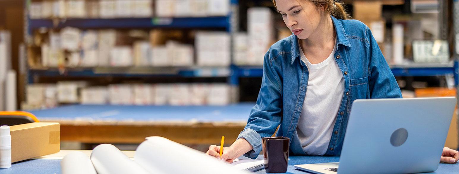 Eine Frau am Laptop optimiert ihr E-Commerce Lager