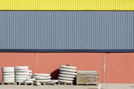 Wand in moderner Fabrikhalle, Betonprodukte im Vordergrund